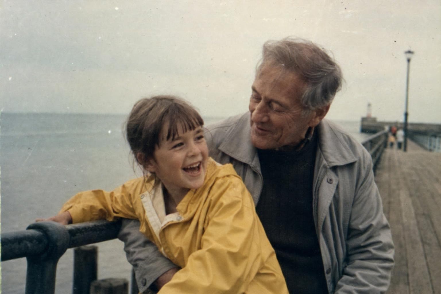 An old, faded seaside home-video frame before restoration